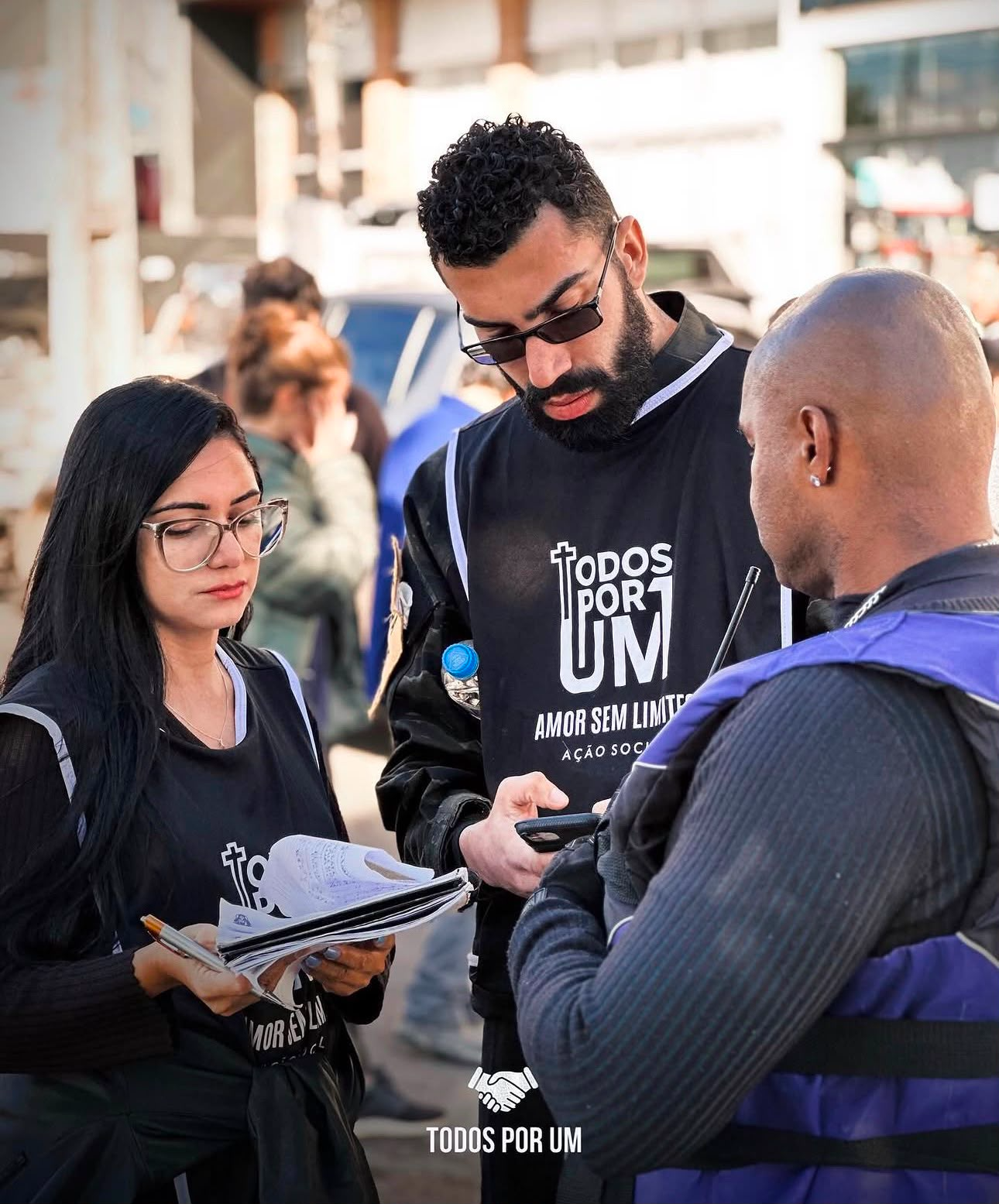 Voluntários da Todos Por Um organizando a lista de atendimento em uma ação na rua